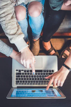 Three users gathered around a laptop