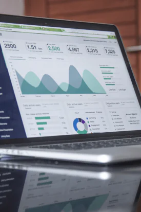 A laptop on a table showing data in a graph