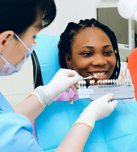 A smiling woman sitting in a dentist's chair having her teeth examined.