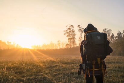 A man in full uniform on a field with the sun shining