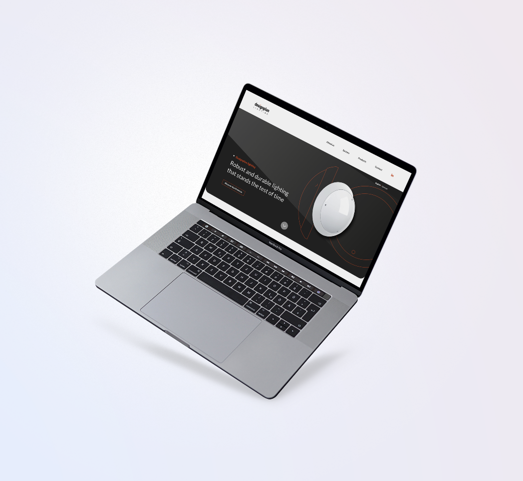 A laptop displaying a website with a dark theme and a spherical graphic. The screen shows text and a simplified navigation menu. The laptop is placed at an angle on a light gradient background.